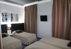 休达鲁伊兹广场旅馆的酒店客房设有两张床和电视。