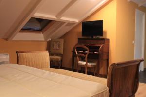 卡卡韦洛斯Hostal Siglo XIX的一间卧室配有一张床和一张书桌及电视