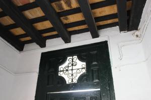 科尼尔-德拉弗龙特拉Apartamento Fatima的木天花板的房间里设有一扇黑色的门