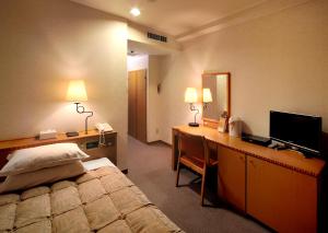 鹿儿岛鹿儿岛太阳皇家酒店的酒店客房配有一张床和一张带电脑的书桌
