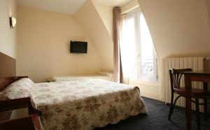 巴黎豪华酒店的一间卧室设有一张床、一个窗口和一张桌子