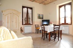 马焦内Appartamenti La Rosetta的客厅配有桌椅和电视。
