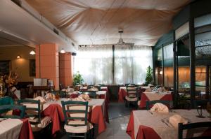 蒂勒尼亚卡瓦列雷尼禄I1酒店的餐厅配有桌椅和红色桌布