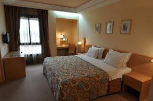 非斯瓦斯姆酒店的酒店客房设有一张大床和一张书桌。