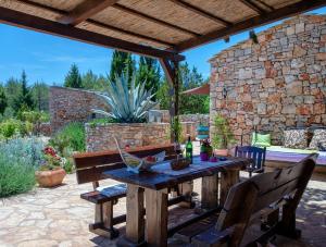 斯塔里格勒欧科萨梦幻别墅的庭院设有木桌、椅子和石墙