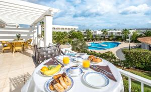 卡拉达沃卡拉达沃奥纳村公寓式酒店的一个带泳池的阳台的早餐桌