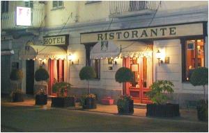 皮内罗洛雷吉纳酒店的建筑前有盆栽的旅馆