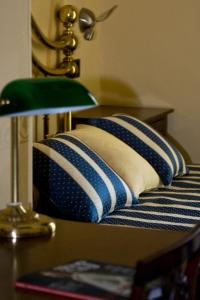 皮内罗洛雷吉纳酒店的一张带两张枕头的桌子和一盏灯的床