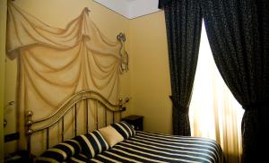 皮内罗洛雷吉纳酒店的一间卧室配有一张带天蓬的床