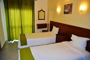 法鲁阿多卡旅馆的酒店客房设有两张床和窗户。