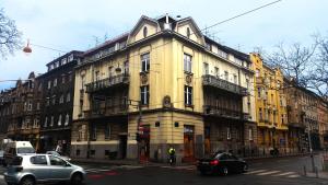 萨格勒布下城公寓的一条大型黄色建筑,位于城市街道上,有汽车