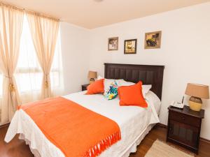 圣地亚哥Sweet Stay Chile的一间卧室配有一张带橙色枕头的大床