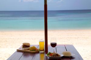 丽贝岛利普岛芭堤雅海滩马里度假酒店的海滩上的一张桌子,上面放着三明治和一杯葡萄酒