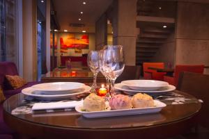 蒙得维的亚AXSUR迪赛恩酒店的餐桌,带食物盘和酒杯