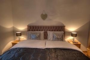 滨湖采尔滑雪和高尔夫​​所卡普伦出租小屋公寓的一间卧室配有一张大床和两盏灯