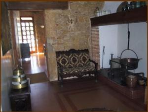 蒙德马桑萨巴拉酒店的一间带壁炉的客厅,位于一座石头建筑中