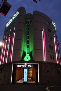 东京HOTEL PAL Otsuka -Adult Only-的上面有 ⁇ 虹灯标志的酒店大楼
