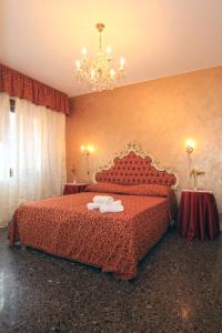 威尼斯里亚托梦幻住宿加早餐旅馆的一间卧室配有一张带红色床单和吊灯的床。