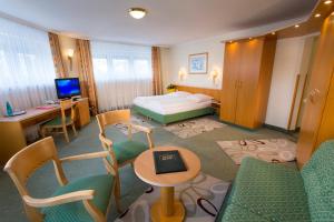 慕尼黑乔克酒店的酒店客房带一张床、一张桌子和椅子