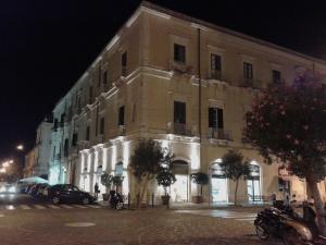 锡拉库扎B&B CARAVAGGIO SIRACUSA basic rooms with bathroom 200 Metres from Ortigia的城市街道上的一个大型建筑