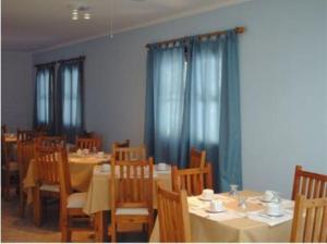 门多萨木拉斯公寓酒店的一间配备有桌椅的用餐室和蓝色窗帘