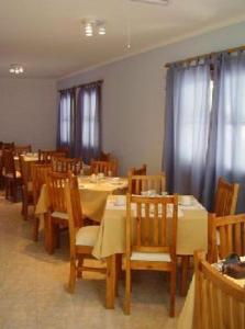 门多萨木拉斯公寓酒店的用餐室配有桌椅和窗帘