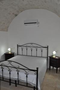 普蒂尼亚诺Masseria Costanza的一间卧室配有一张黑色床和两张床头柜