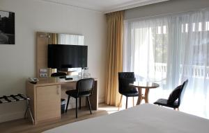 戛纳维多利亚酒店的酒店客房带一张床、一张桌子和椅子