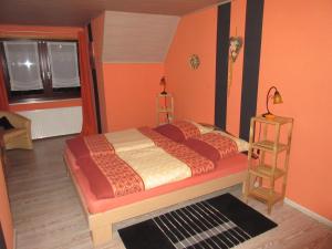 施尔奇Ferienhaus Schulze的一间卧室配有一张带橙色墙壁和窗户的床