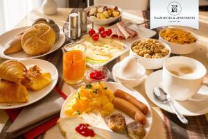 美因河畔法兰克福Naam Hotel & Apartments Frankfurt City-Messe Airport的餐桌,带早餐食品盘和咖啡杯