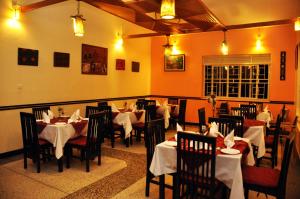 KyabinungaIgongo Country Hotel & Cultural Centre的餐厅配有桌椅和白色桌布