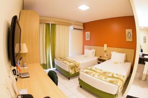 马瑙斯马瑙斯司丽普酒店的酒店客房配有两张床和一张书桌