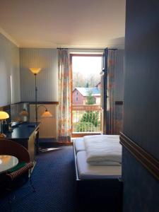 OlbersdorfBB酒店的一间卧室配有一张床、一张书桌和一个窗户。