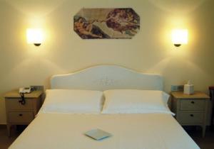 Villongo SantʼAlessandro皮克洛普林西比酒店的卧室配有一张白色的床,上面有书