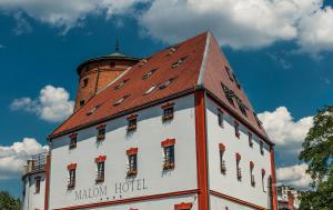 德布勒森马隆酒店的一座白色的建筑,有红色的屋顶和塔
