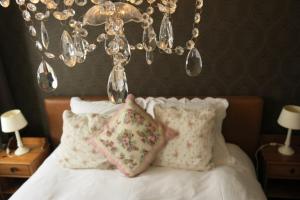 伊普尔伊博利23号度假屋的一间卧室配有一张带枕头的床和吊灯。