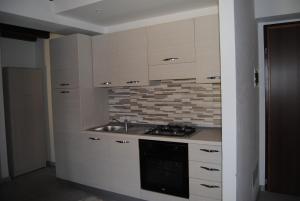 莱泽诺Casa da Giorgia的厨房配有白色橱柜、水槽和炉灶。