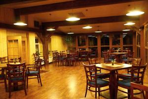 利特威诺夫Hotel Emeran的一间带木桌和桌椅的餐厅