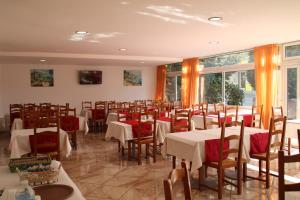 卢尔德卢泰西亚酒店的一间设有桌椅和窗户的用餐室