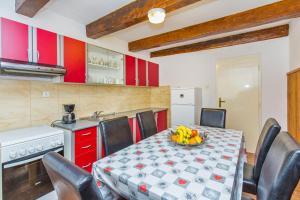 默克斯卡蒙科维奇公寓的厨房配有桌椅和红色橱柜