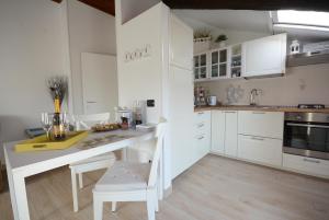 科莫Appartamento Franca的厨房配有白色橱柜和白色的桌椅