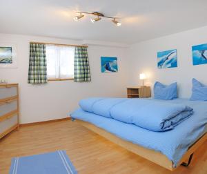 采尔马特利奥波德豪斯旅馆的一间卧室配有一张带蓝色床单的大床