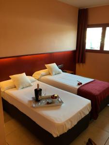 拉洪克拉拉洪奎拉酒店的一张位于酒店客房内的两张床,配有一个食品托盘