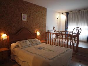加尔甘塔劳利亚耶斯特旅舍的卧室配有一张床和一张桌子及椅子