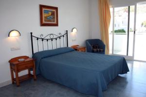 圣何塞布里萨玛尔旅舍的一间卧室配有蓝色的床和蓝色椅子