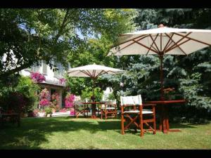 康布雷精艺轩酒店的院子里设有两张桌子和椅子,配有遮阳伞
