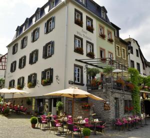 拜尔施泰因贝尔斯坦旅馆的前面有桌子和伞的建筑