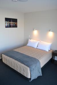 基督城319号阿丁顿汽车旅馆的一间卧室配有一张带蓝色毯子的大床