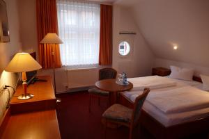 格赖夫斯瓦尔德Hotel Am Dom的酒店客房配有一张床铺和一张桌子。