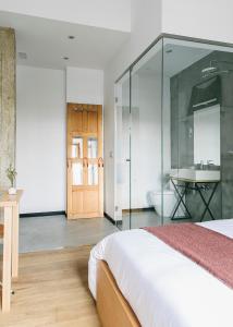 圣塞瓦斯蒂安Guest House Ibaia Et Arramak的一间卧室配有一张床,浴室设有水槽